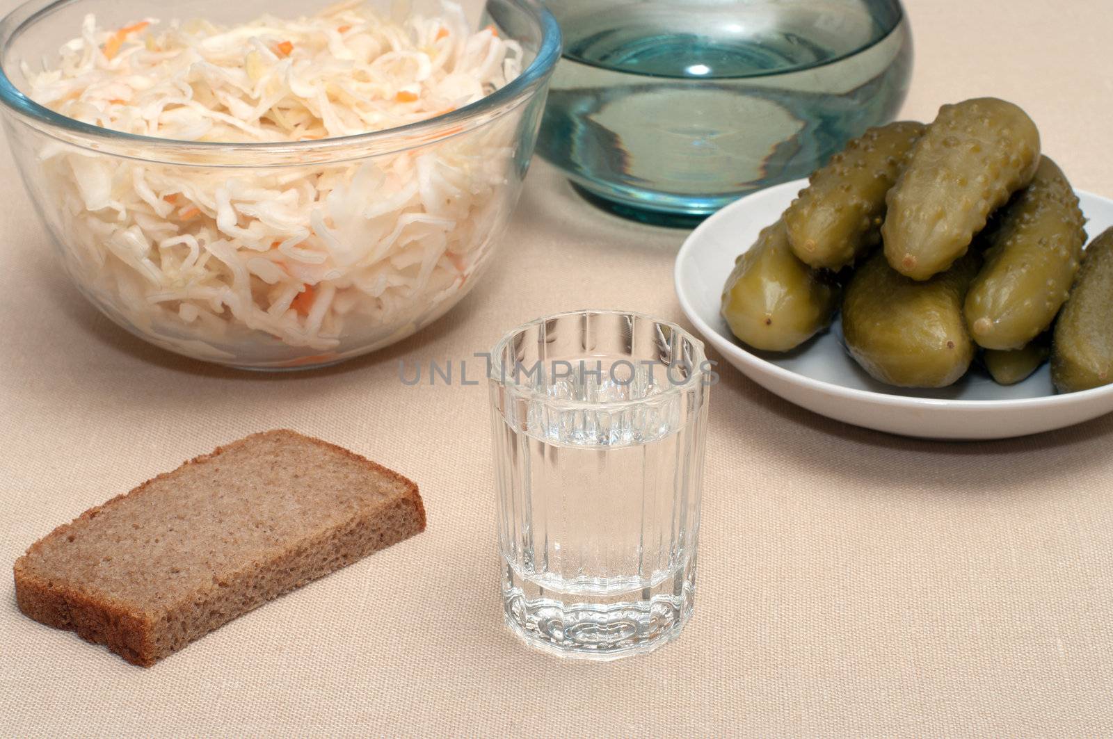 Wine-glass of vodka pickles and sauerkraut close up.