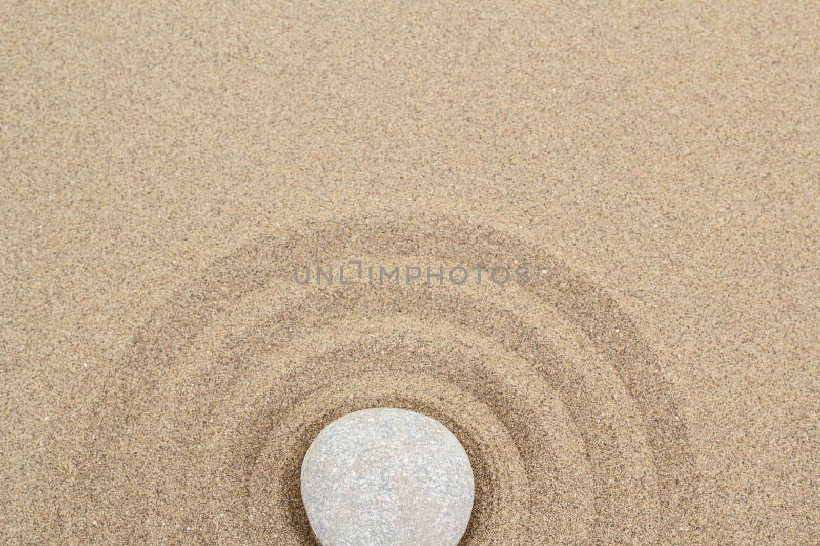 zen stones in soft sand with circles