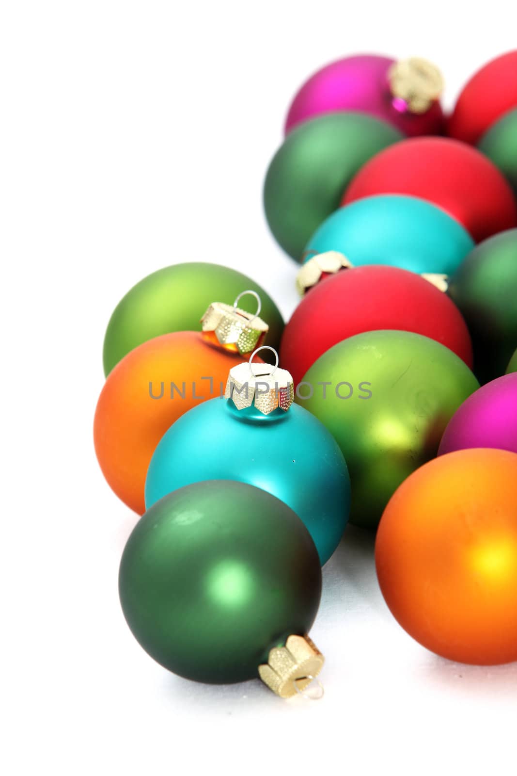 Studio shot over white of a selection of colourful Christmas tree baubles with space for your text