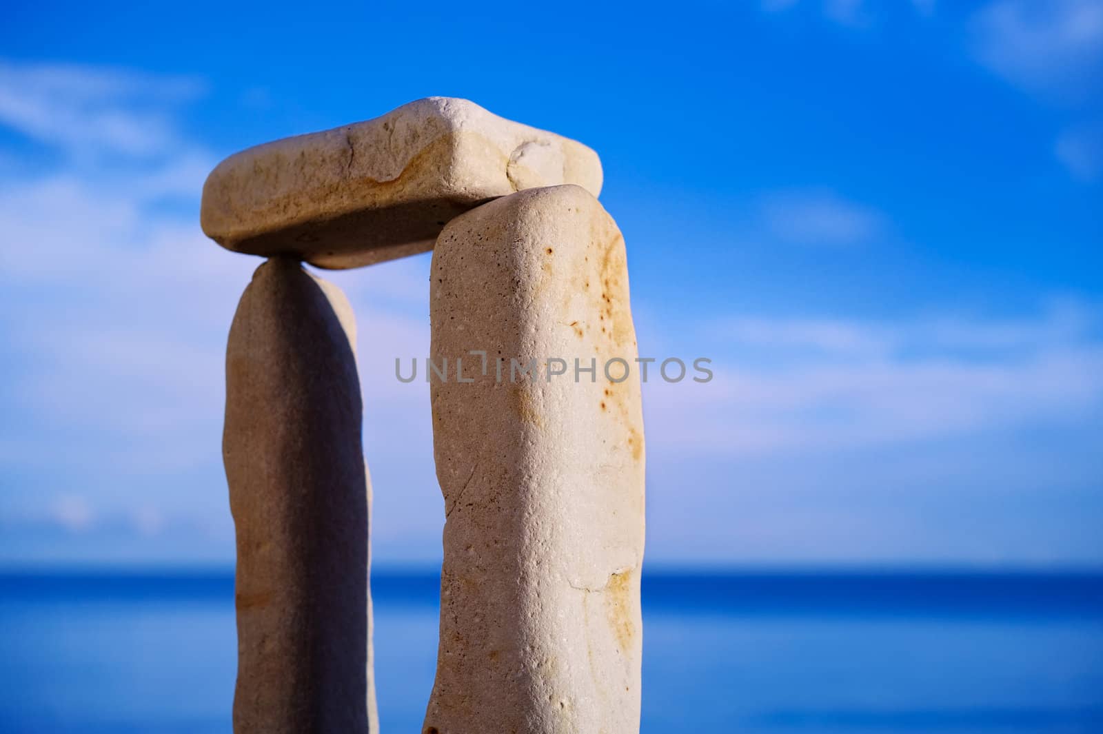 Balancing of three white pebbles on the sea coast