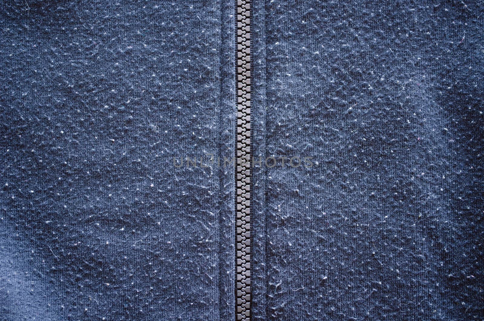 jumper robe garment zipper zipped and well worn fabric background closeup.