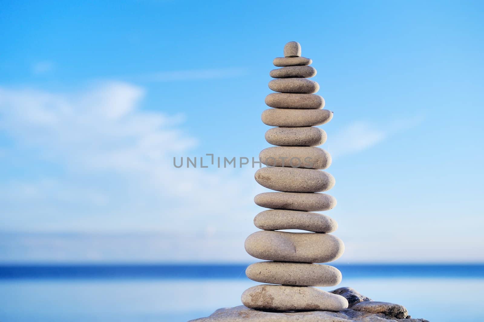 Balancing white pebbles each other on a sky background