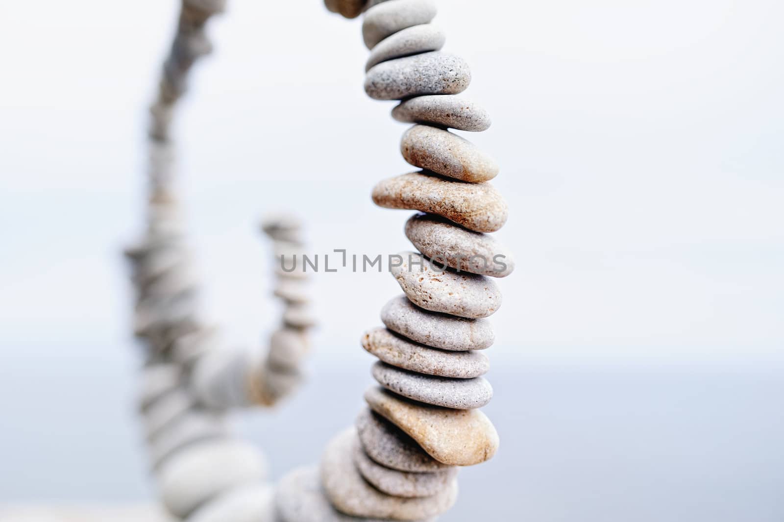 White spiral of pebbles on a sky background blur