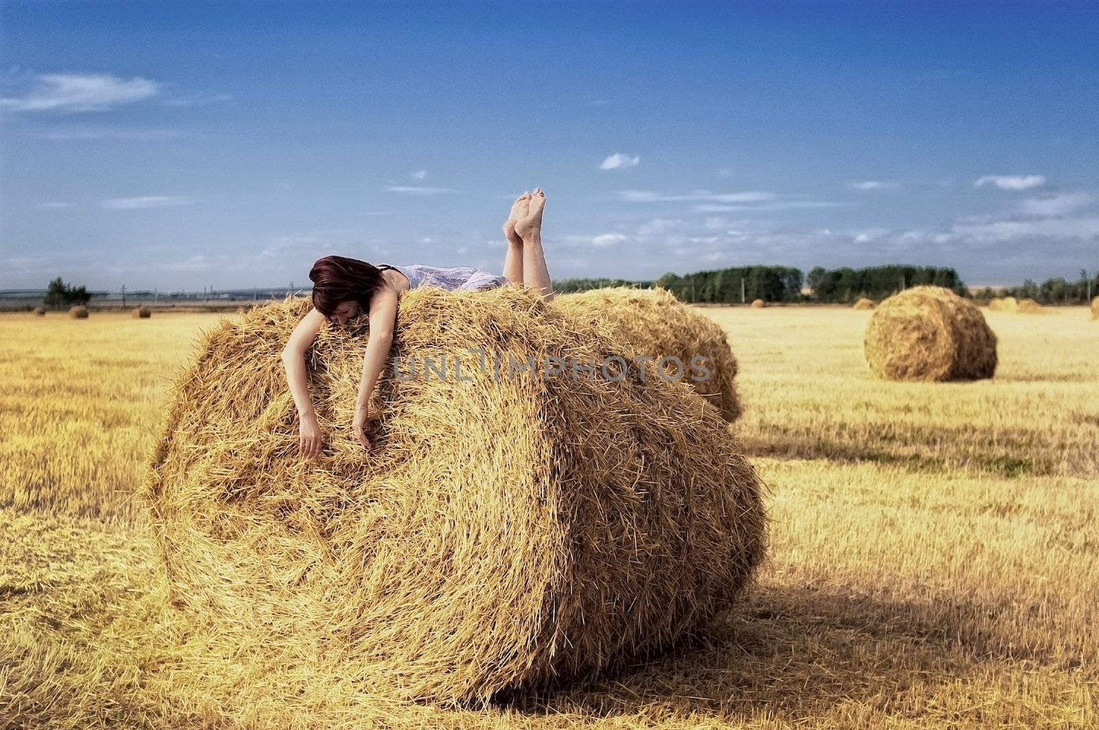 woman on a haystack in a field outside the city