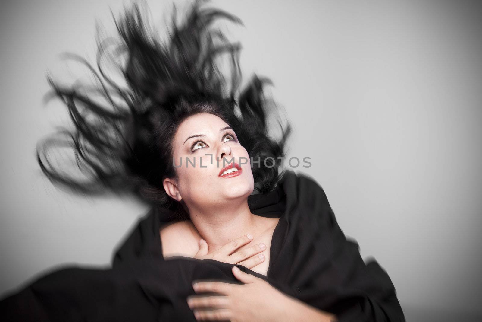 Beautiful woman in studio shot with wind on hair .