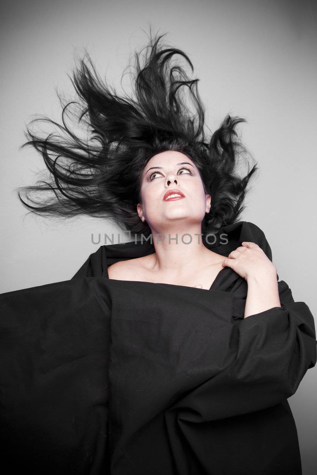 Dark concept, Brunette woman in studio shot with wind on hair .