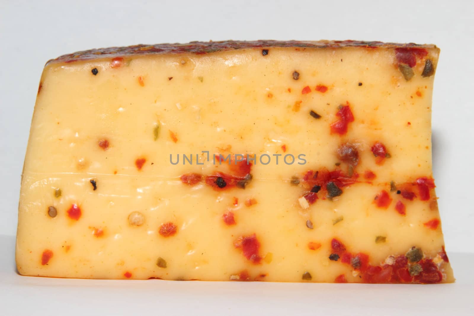 Piece of cheese with red bell pepper and spices