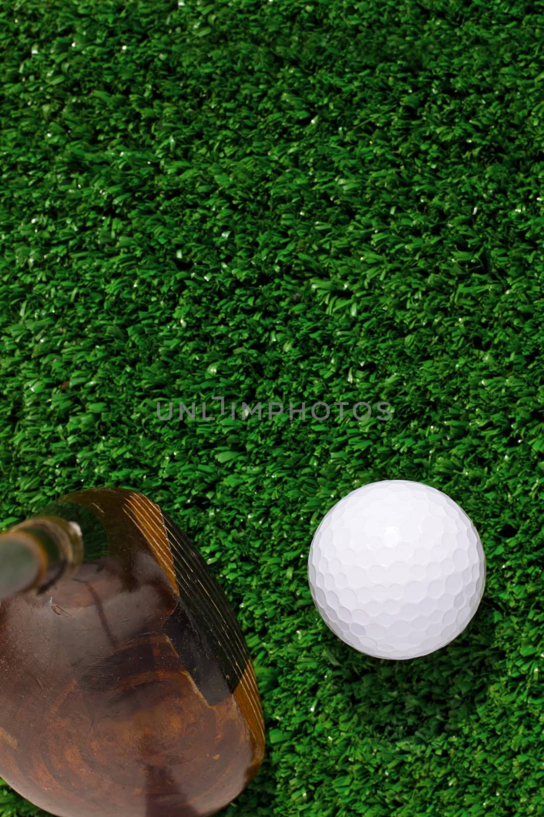 Golf ball and driver on green grass