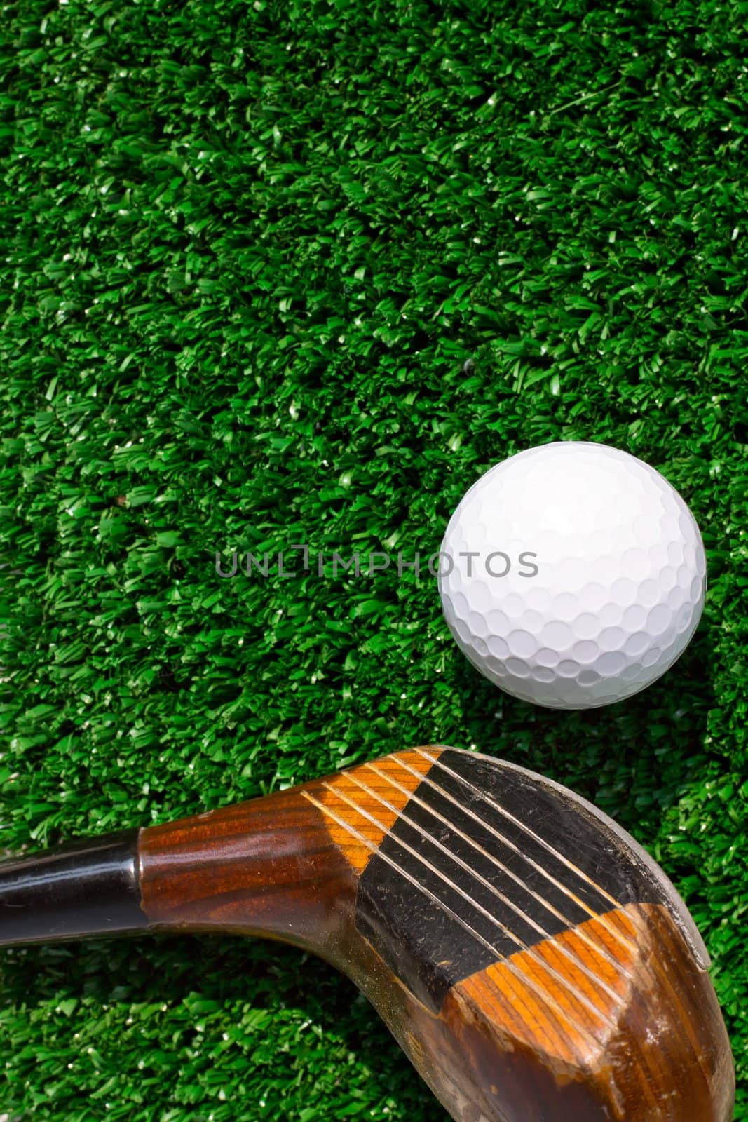 Golf ball and putter on green grass by ponsulak