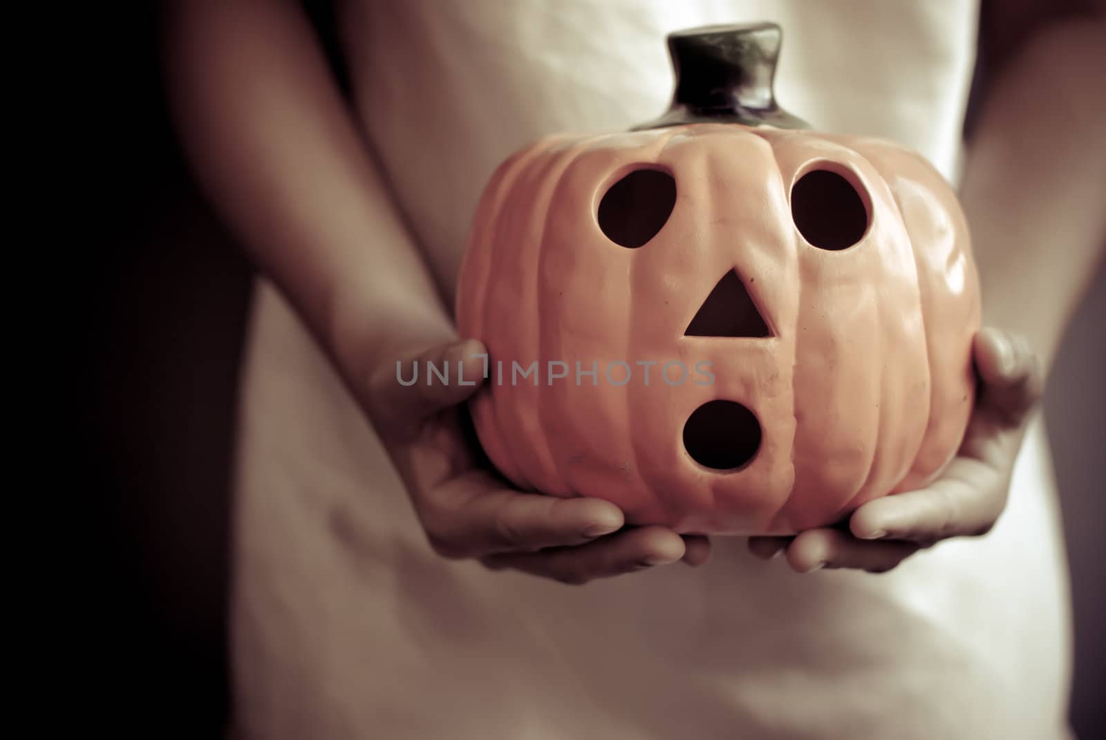 a child holds the pumpkin