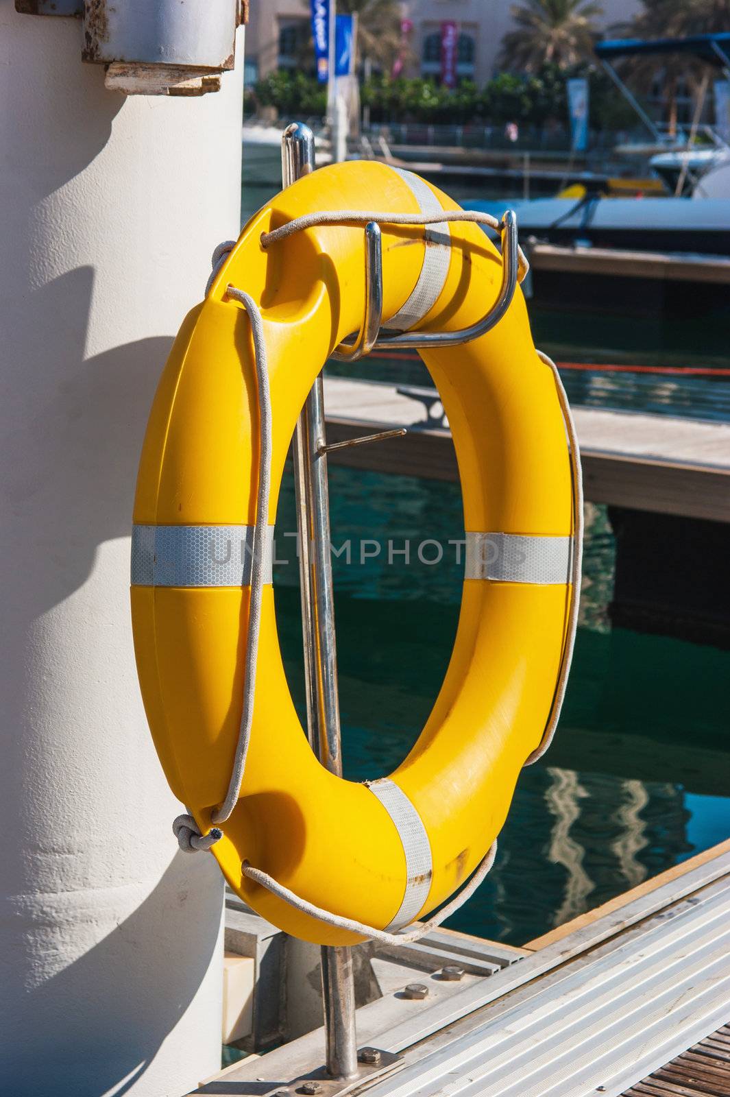 Yellow life buoy on the sea pier in yacht club
