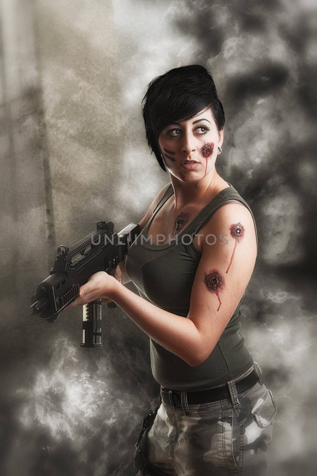 wounded special tactics sexy woman holding up her weapon in a battlefield