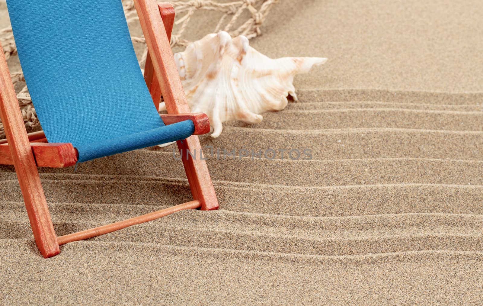 Still Life with seashell, and sun lounger in beach sand