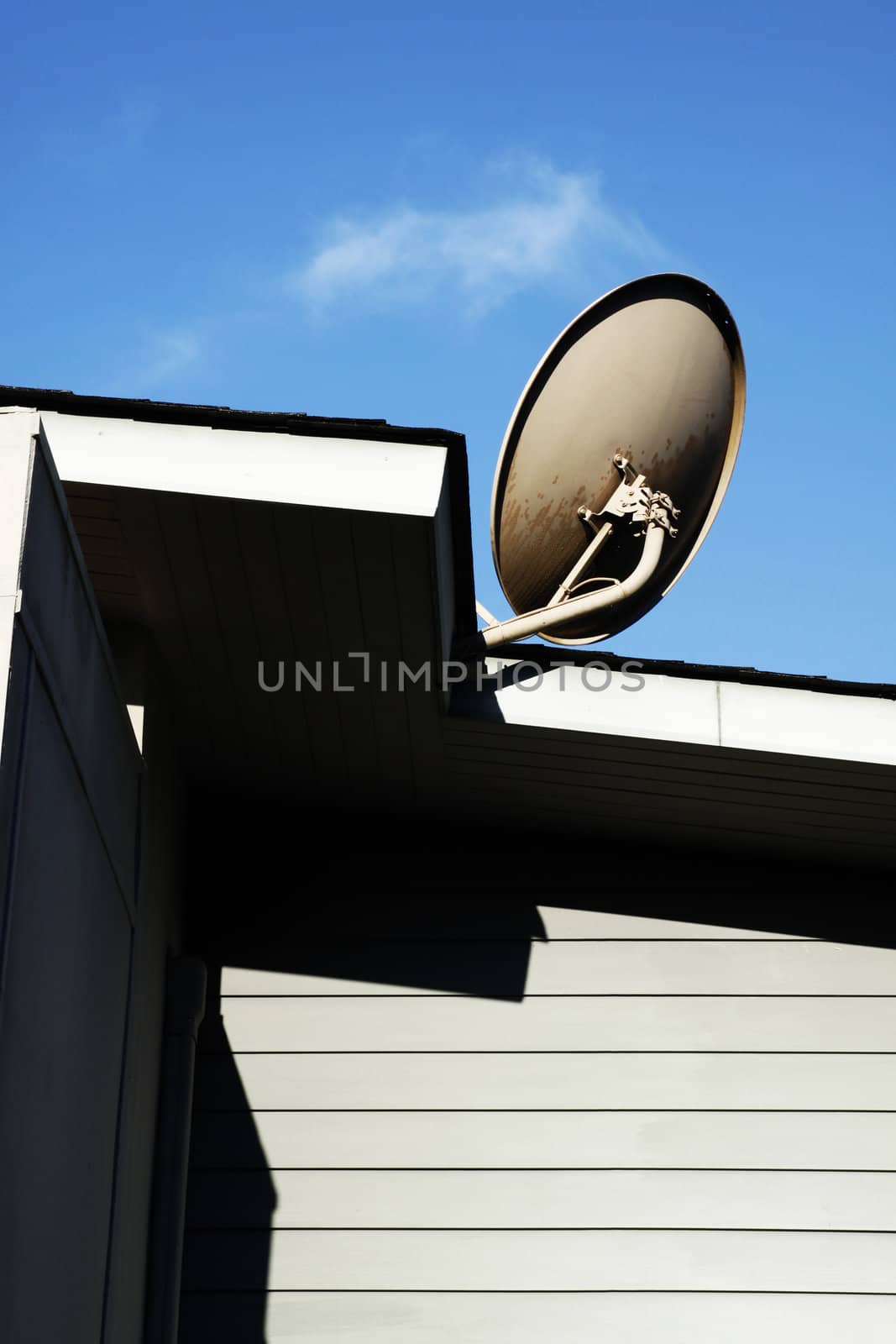 Satellite dish mounted on the roof with blue sky 