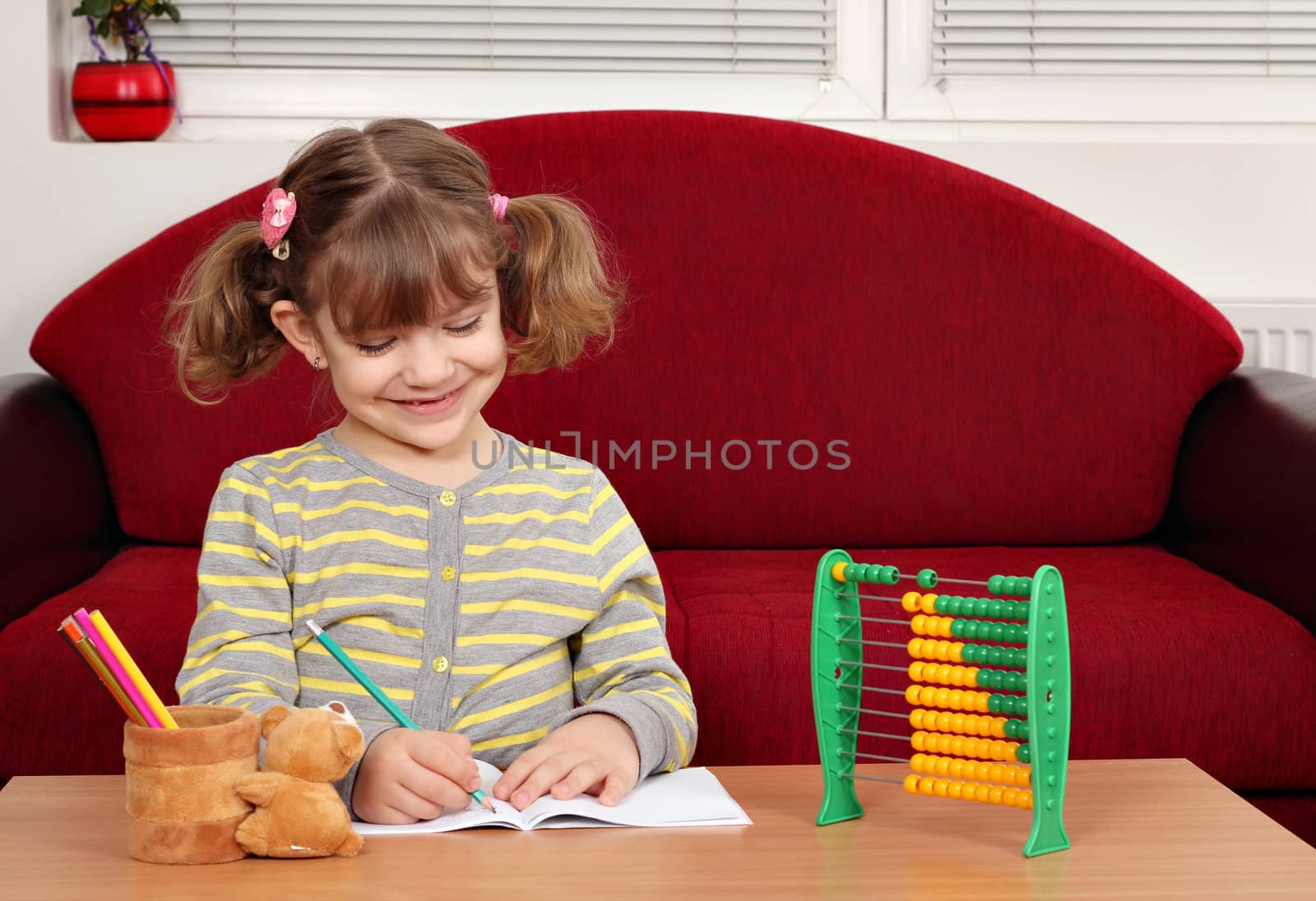 happy little girl doing homework