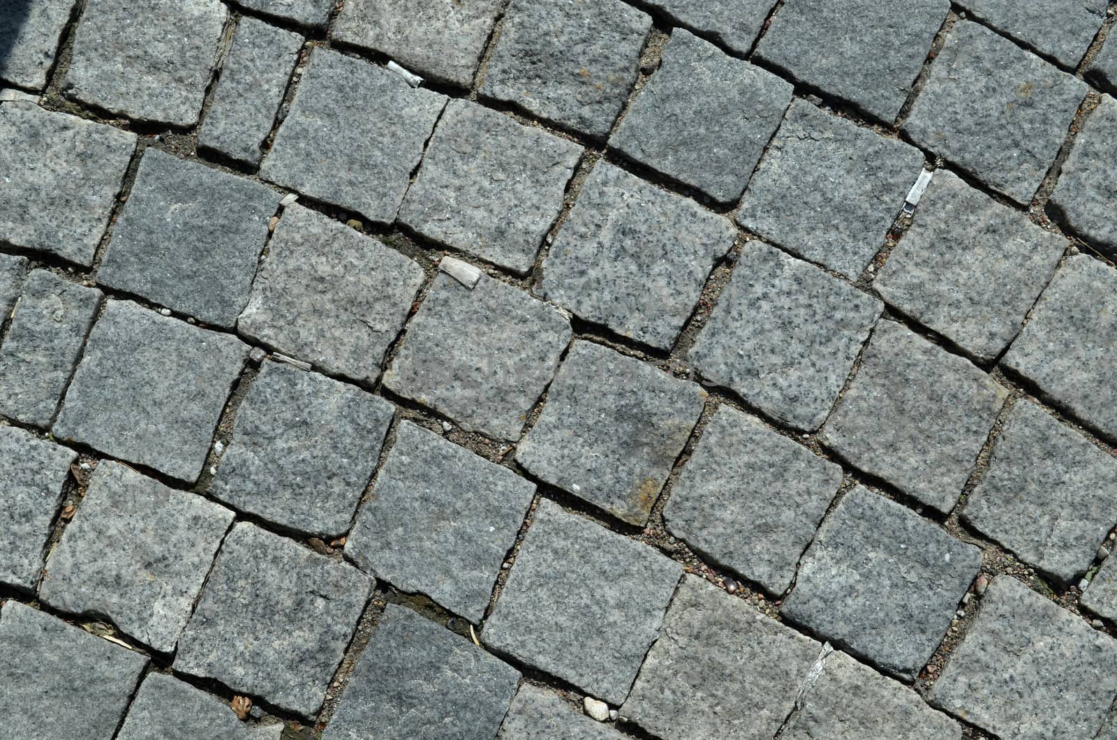 grunge cobblestone tile road abstract background closeup and cigarette butts stubs on it.