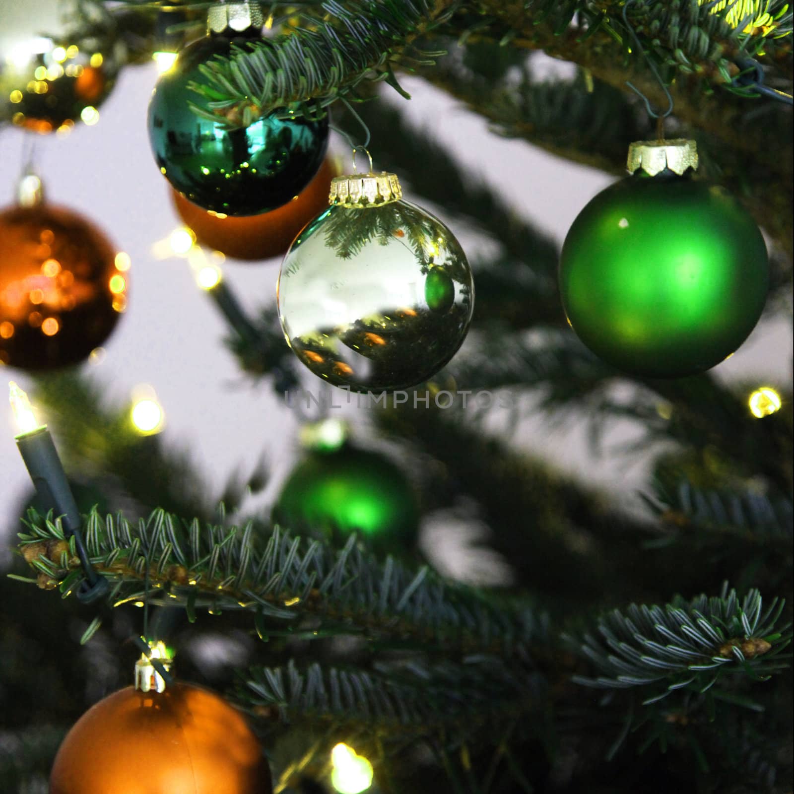 Christmas tree with shiny decorative green globes, close up