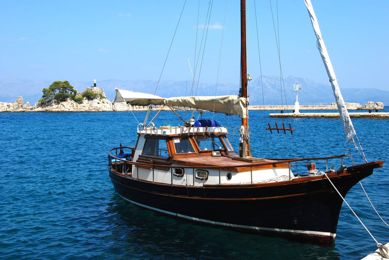Small sailboat in Mediterranean port in summer day