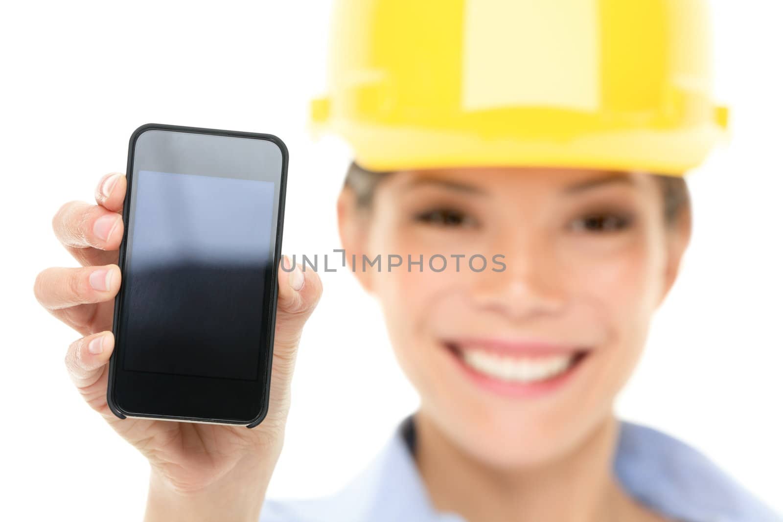Engineer woman showing smart phone wearing construction hard hat. Young female mixed race Asian / Caucasian female professional isolated on white background.
