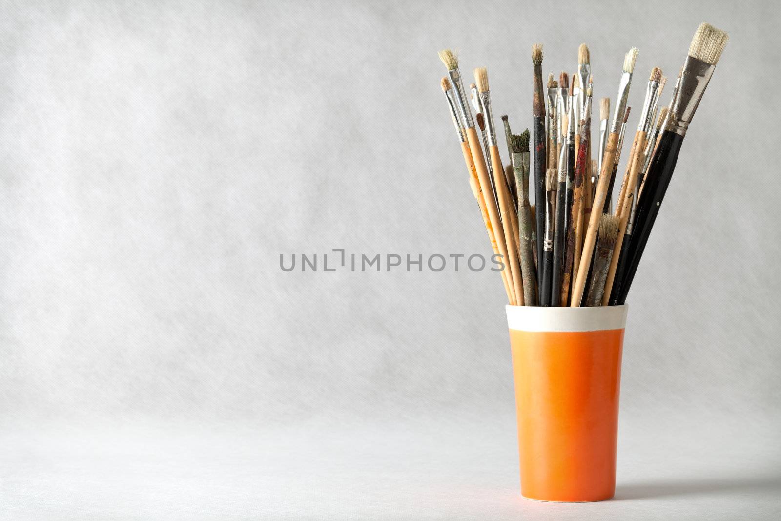 Art paint brushes in cup with empty room for text