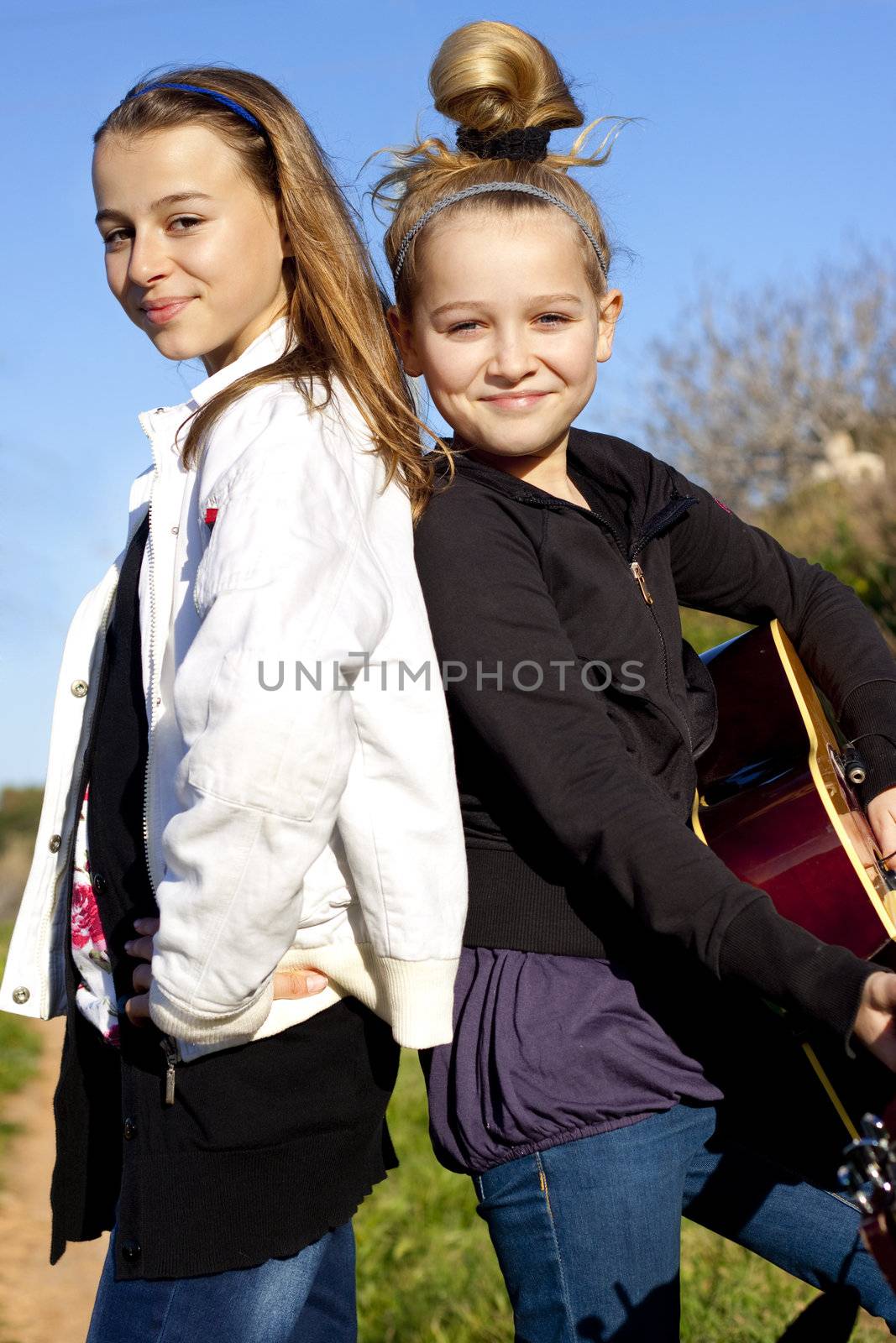 Two kids with posing with a guitar