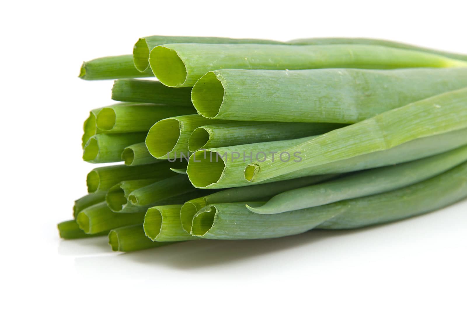 Front view of a pile spring onions in closeup isolated on white background