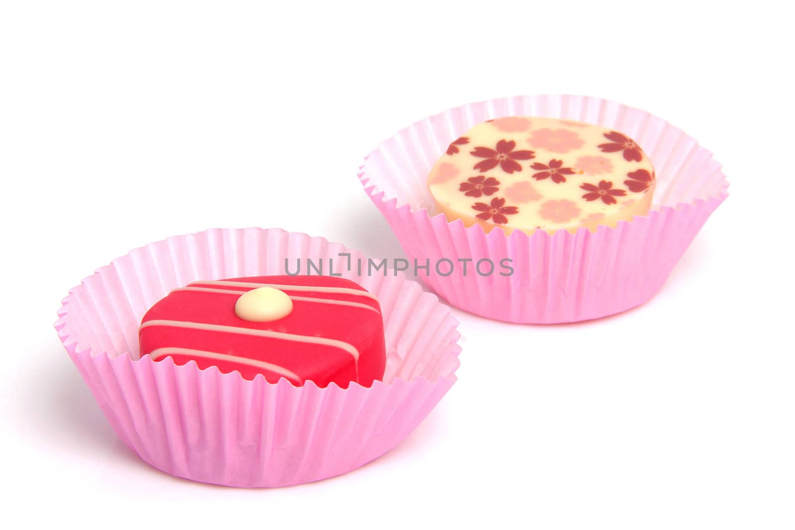 two delicious pink petit four over white background