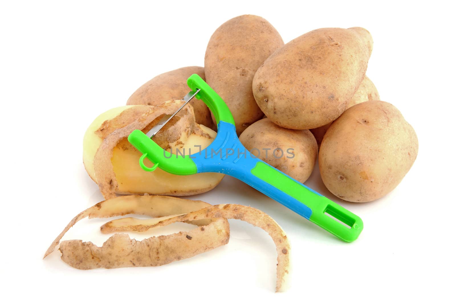 Stack of unpeeled potatoes with colorful peeling knife isolated on white background