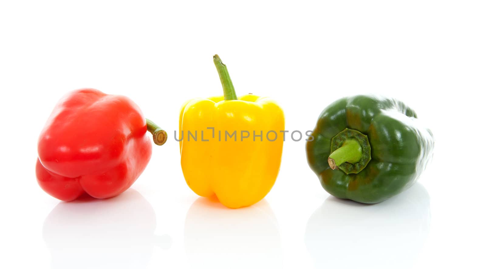Three fresh paprika ( red, yellow and green) over white background