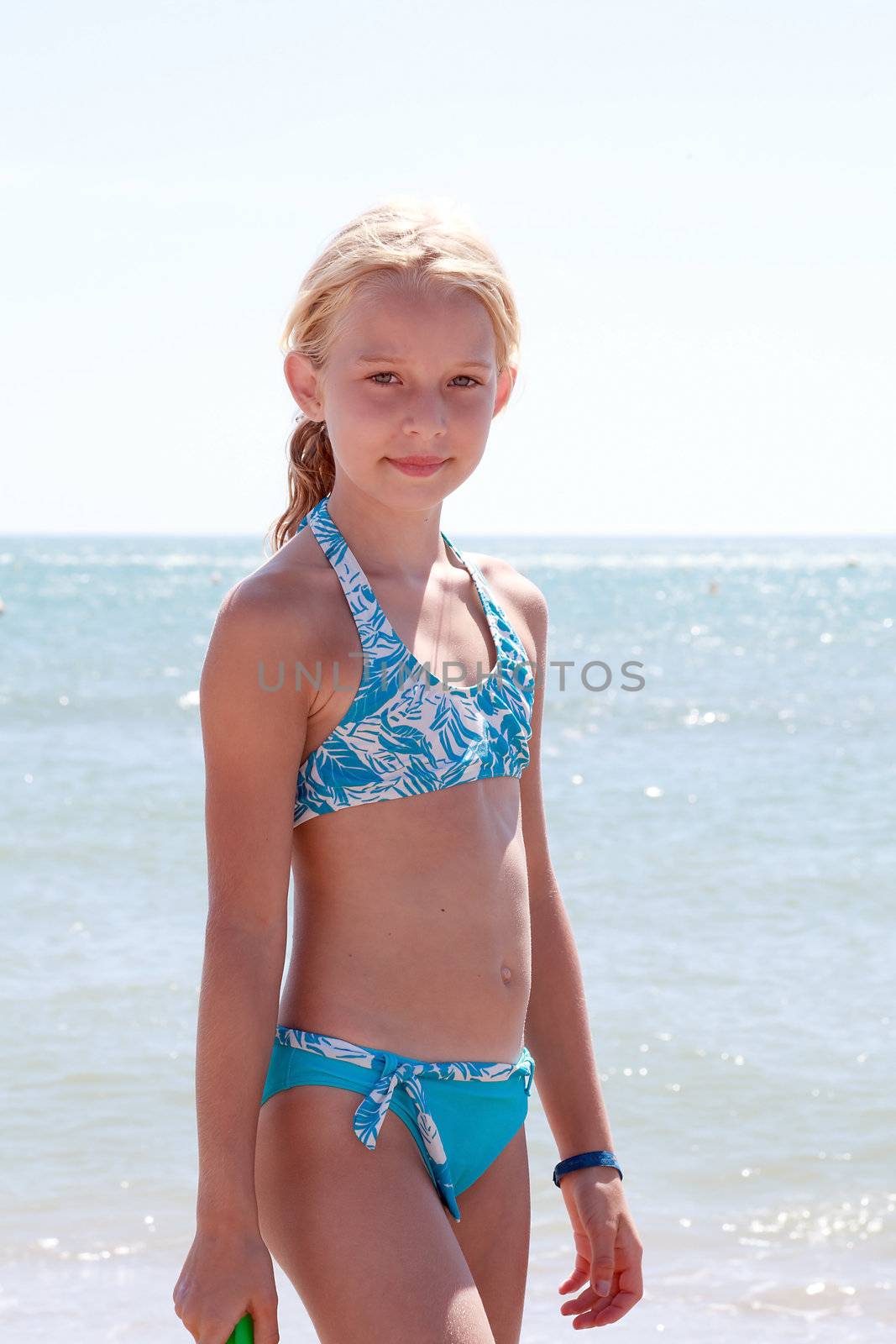 Girl at the beach in bikini looking into camera