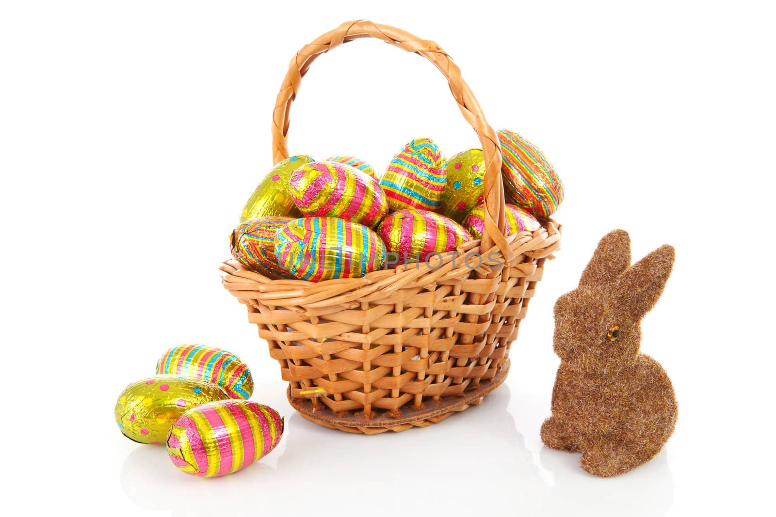 Cane basket with colorful easter eggs and bunny over white background