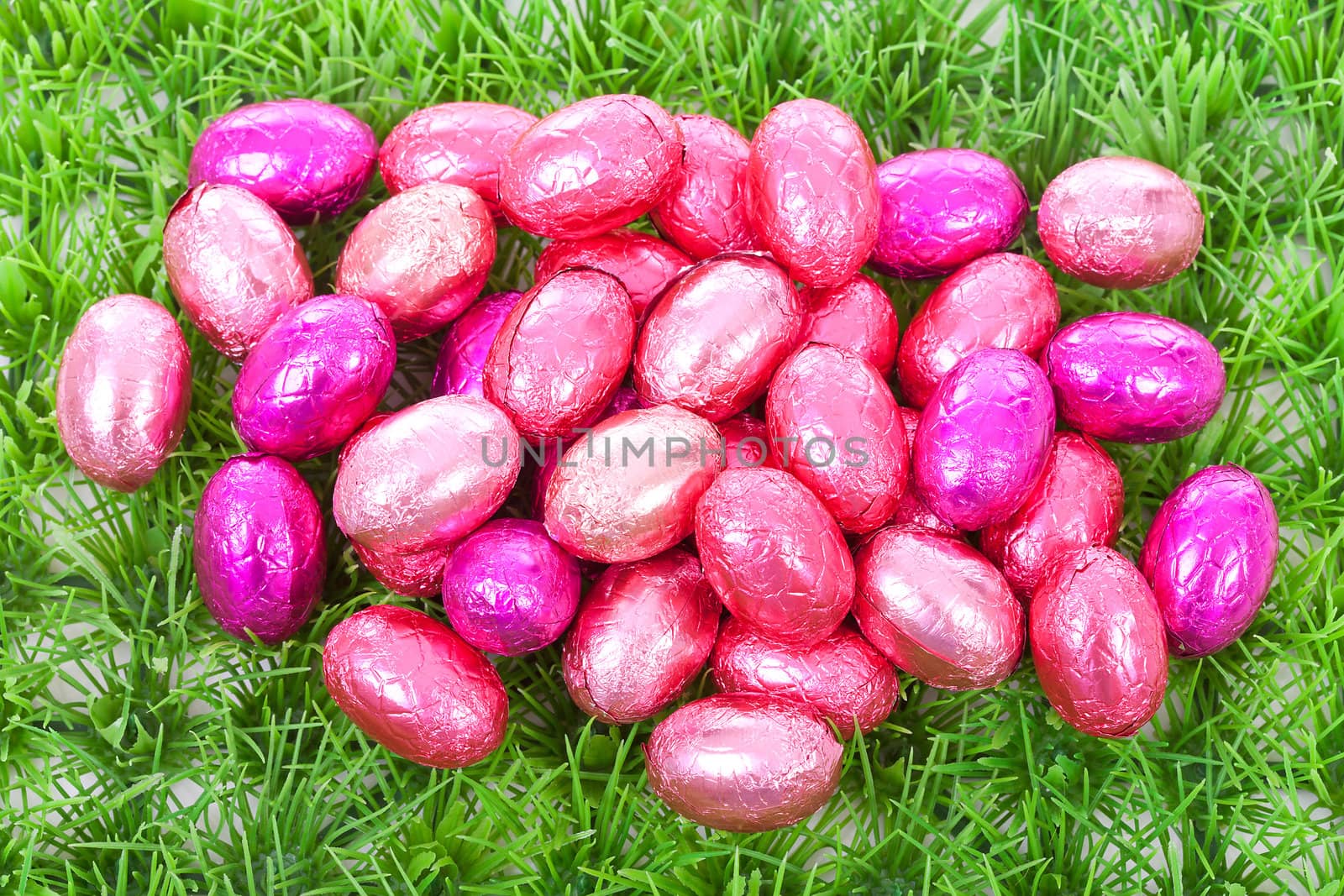 Pink easter eggs on grass in closeup