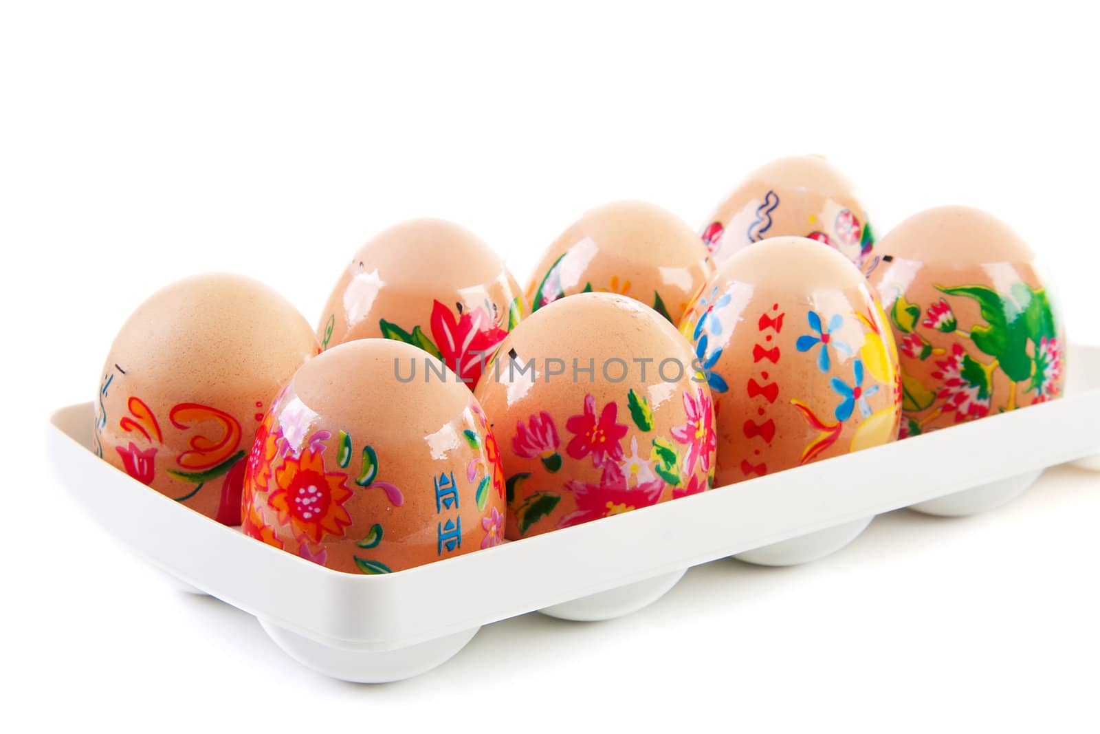 chicken eggs decorated by children for easter in white holder over white background