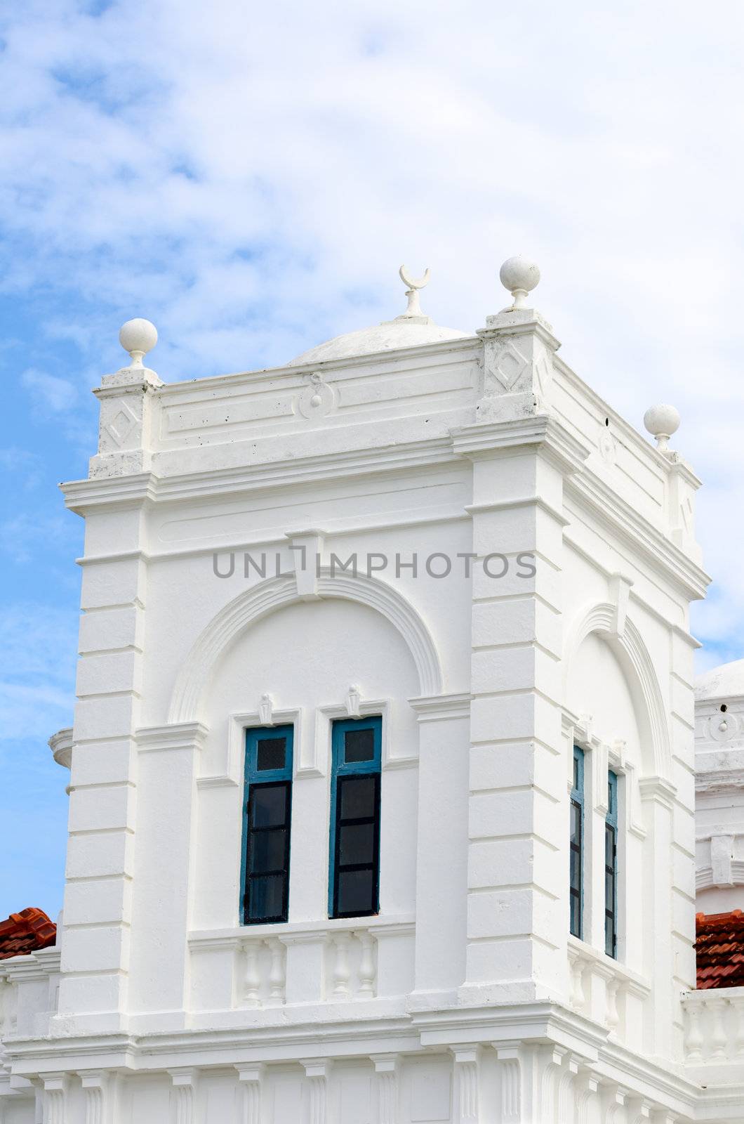 White mosque tower with muslim Crescent on the top with cloudy  sky on background, Galle, Sri Lanka
