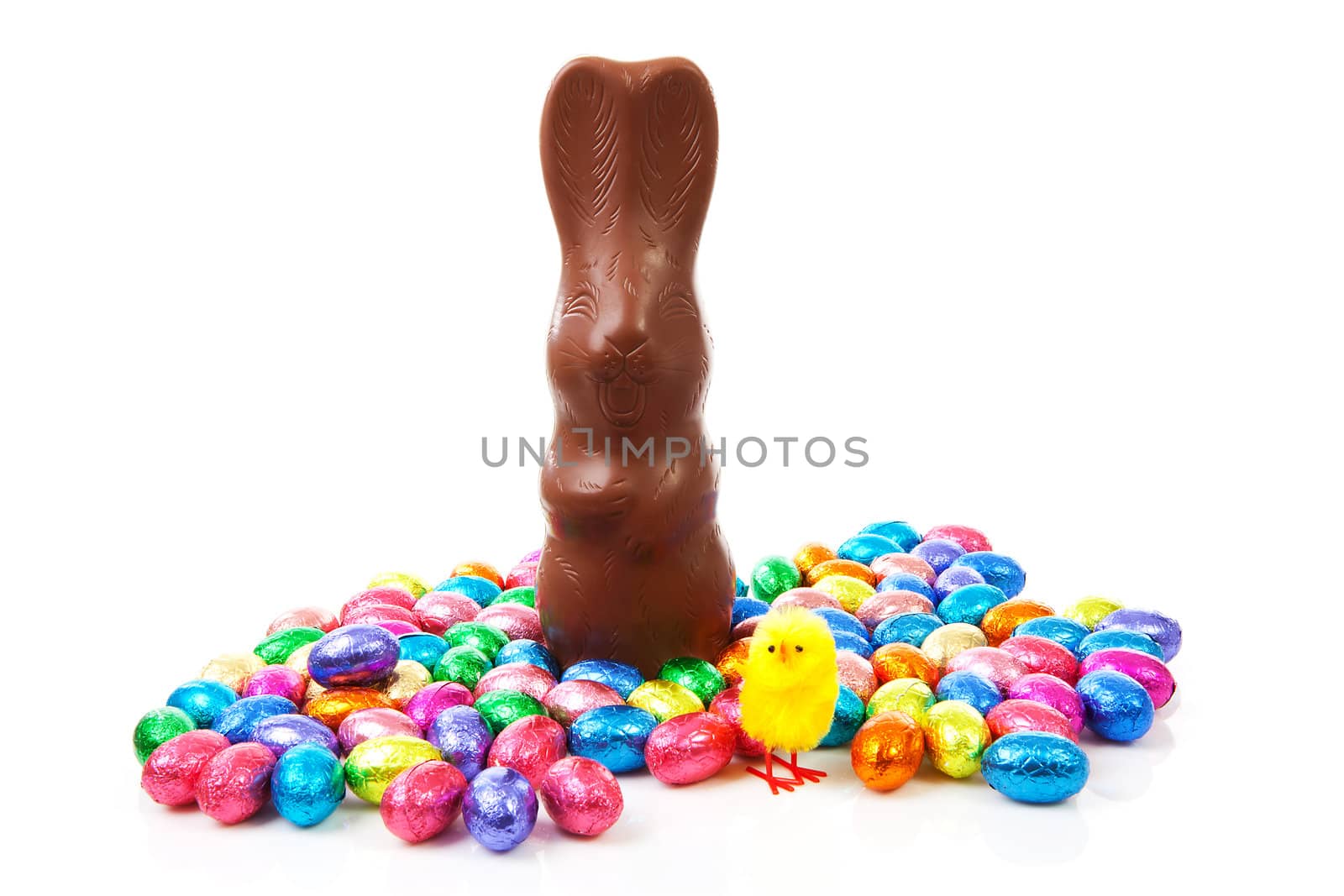 Milk chocolate easter bunny and colorful eggs over white background