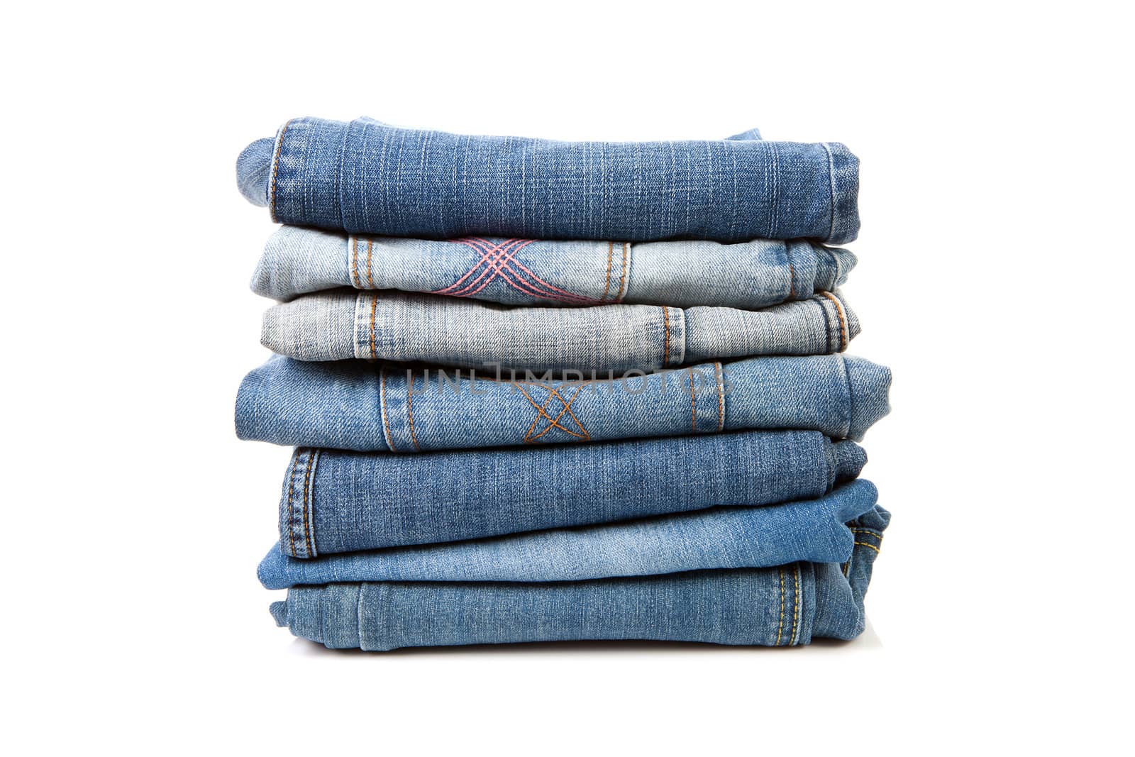 Pile of blue  jeans over white background