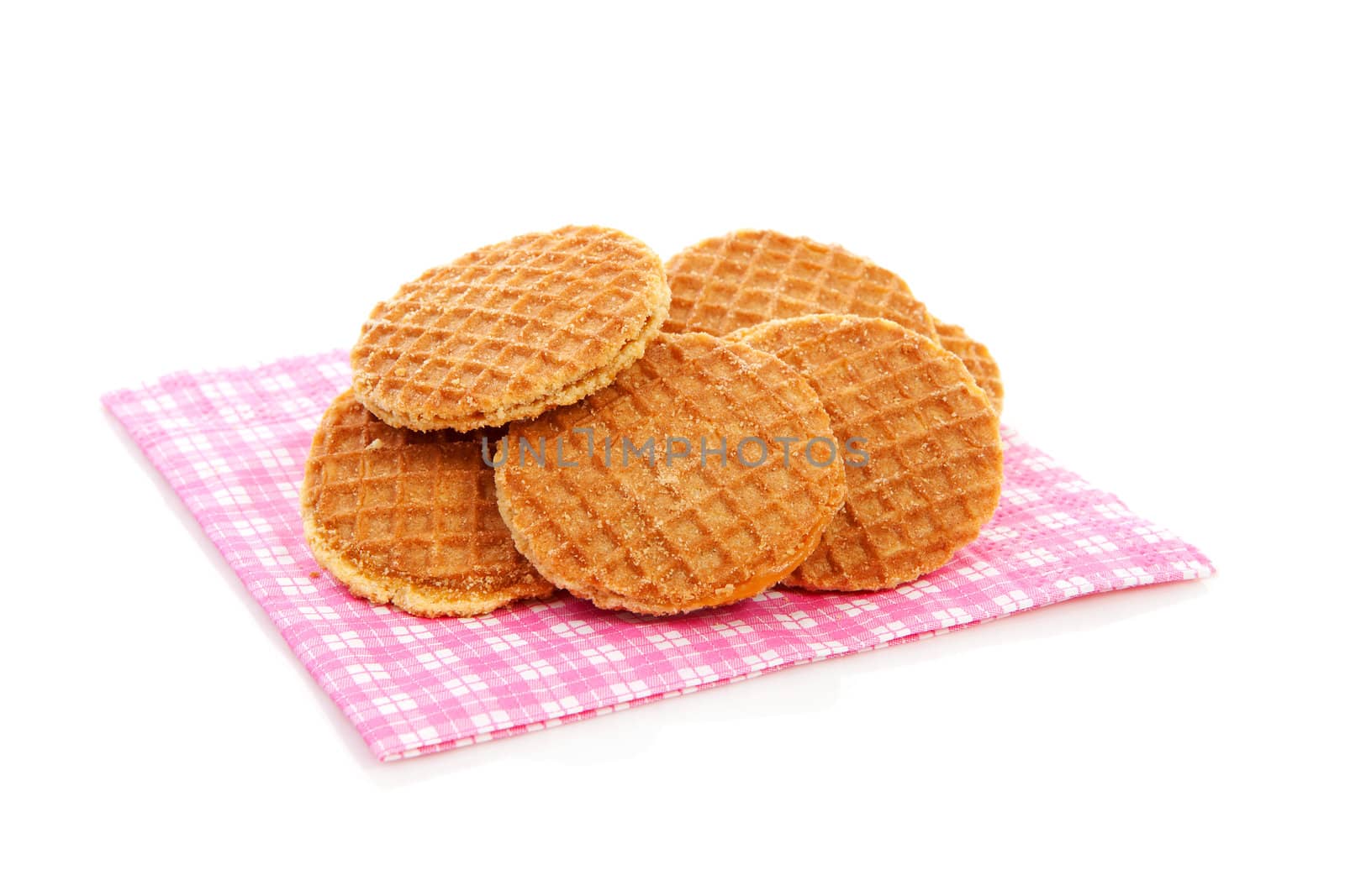 Pile of typical Dutch stroopwafels ( with syrup) on napkin over white background