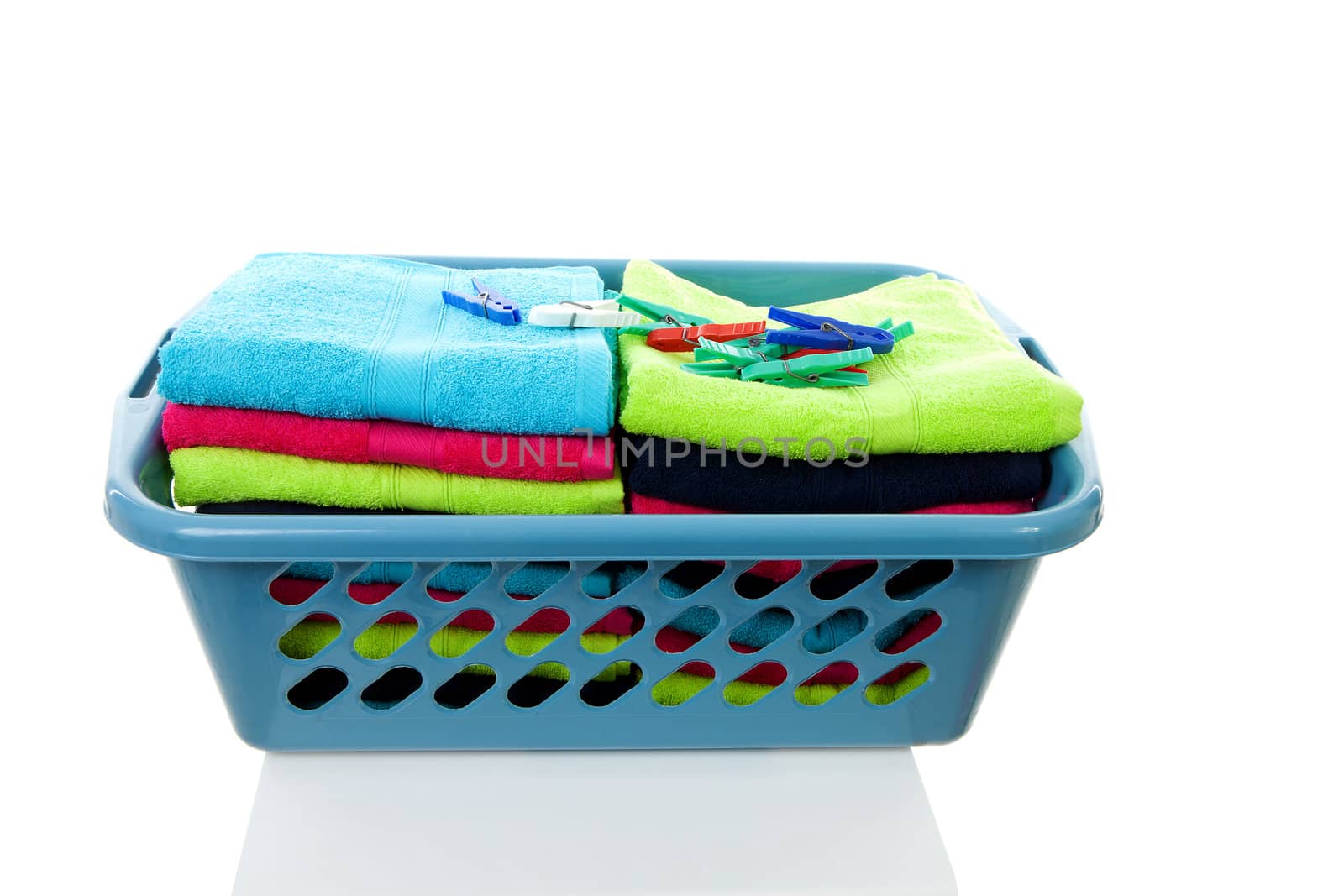 Laundry basket filled with colorful folded towels over white background