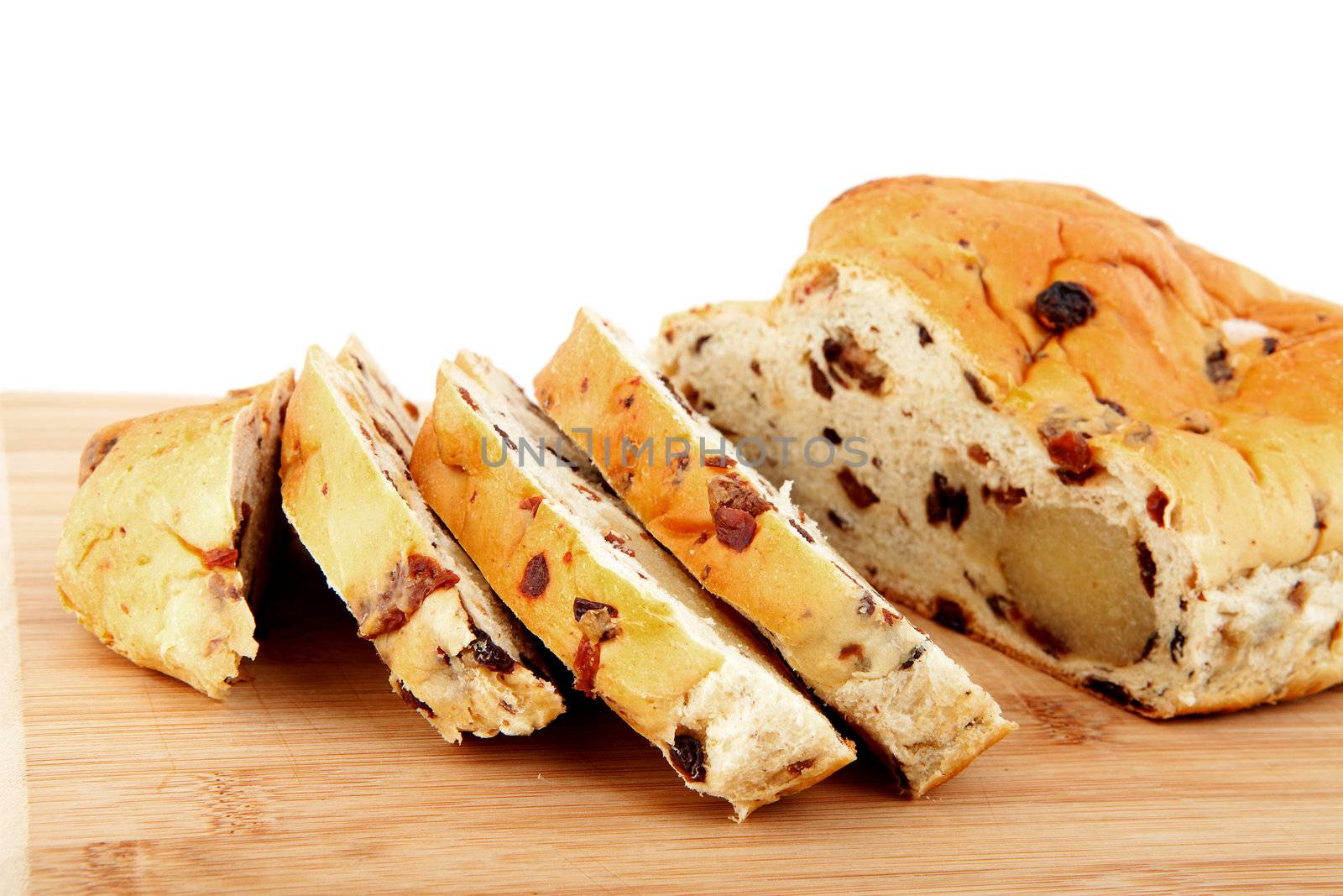 slices of raising bread on wooden cutting board over white background