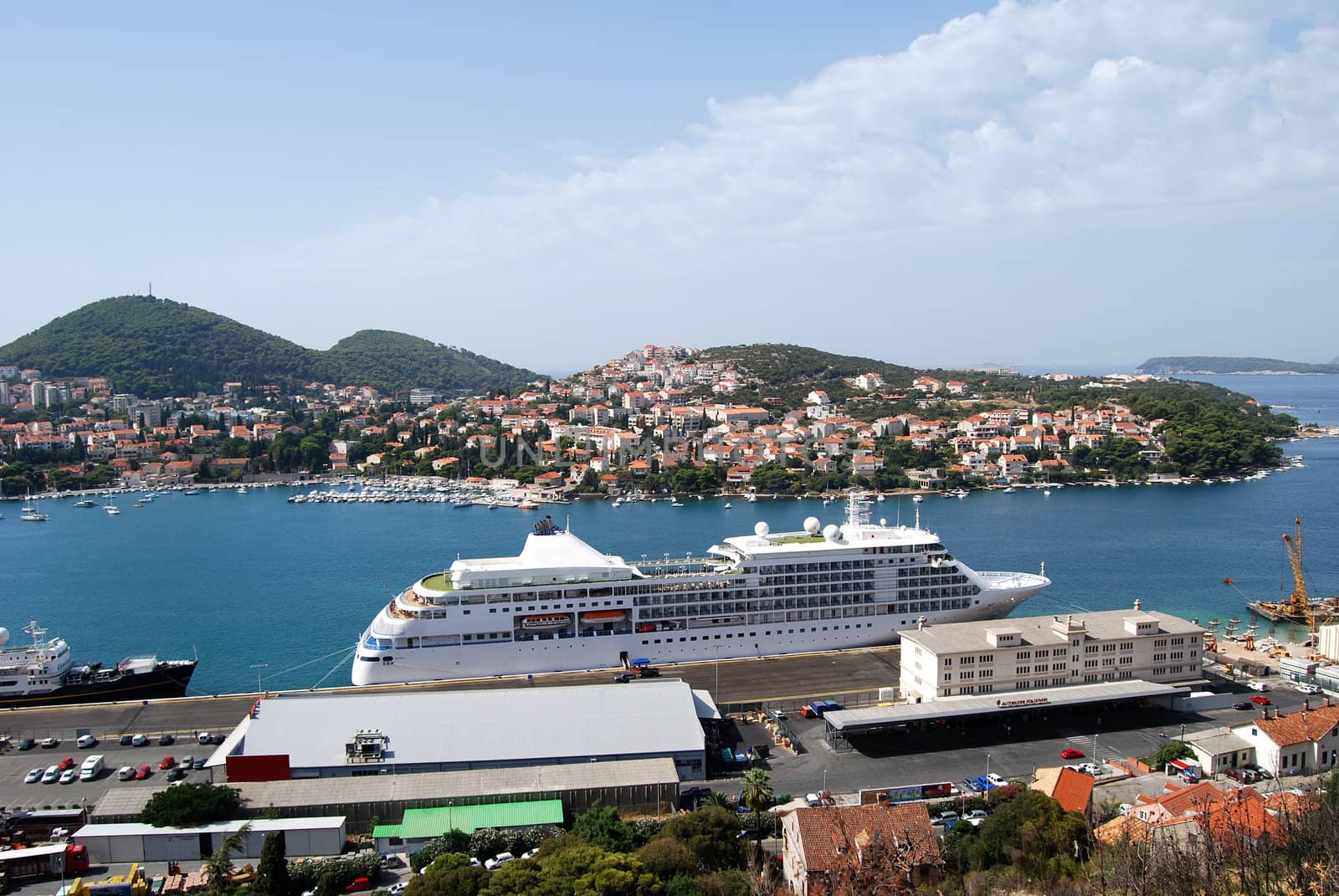 Large cruise ship in old Mediterranean town harbour