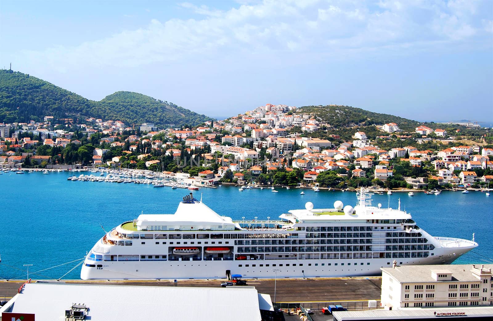 Large cruise ship in old Mediterranean town harbour