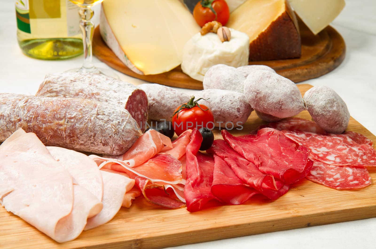 composition of cold cuts  on wooden board with different type of cheese 