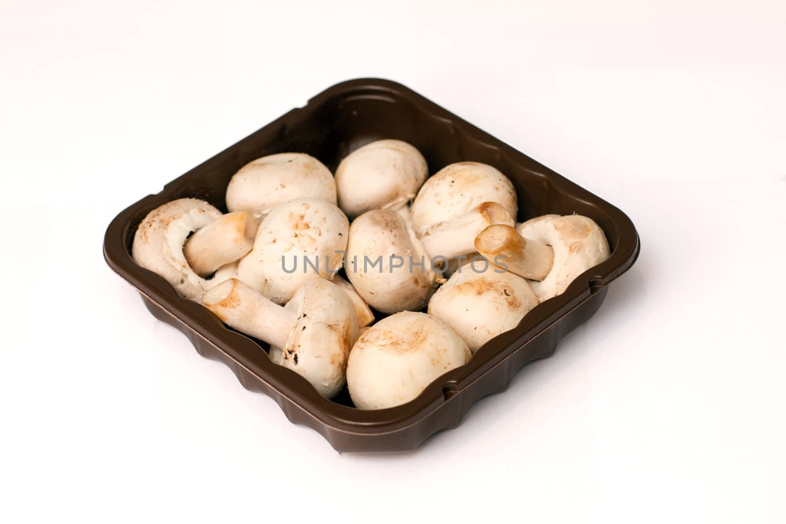 isolated mushrooms in a brown packaging tray
