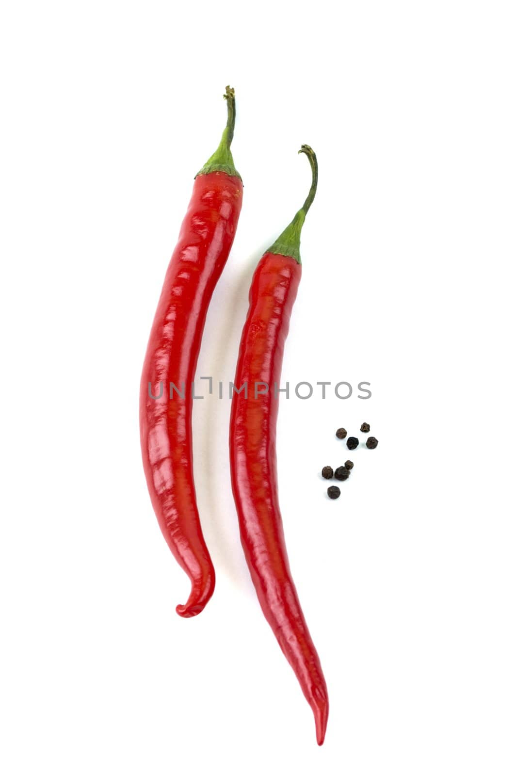 two chili peppers and pepper peas on a white background
