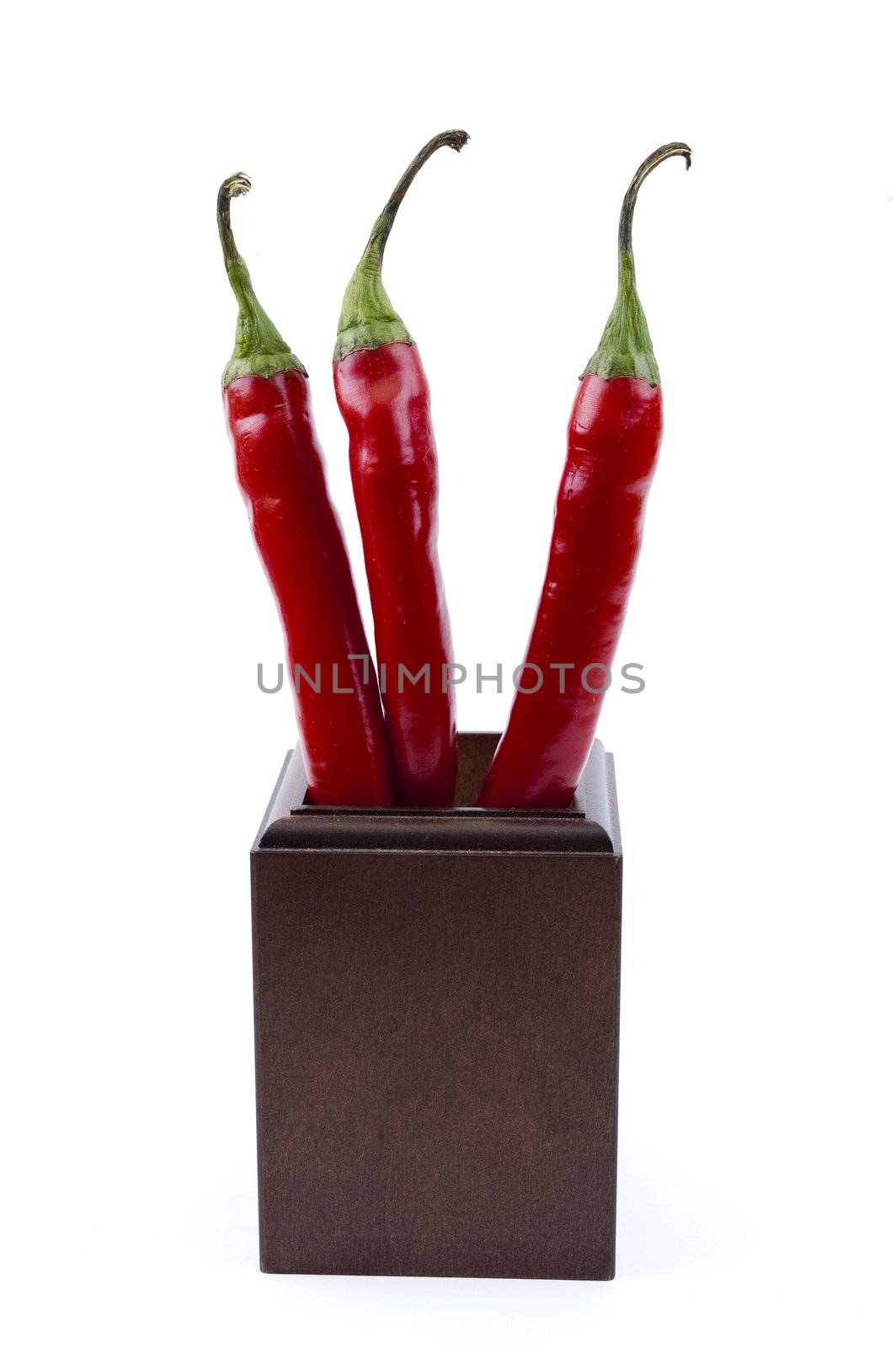 the top three chili peppers in a wooden cup by Triphka