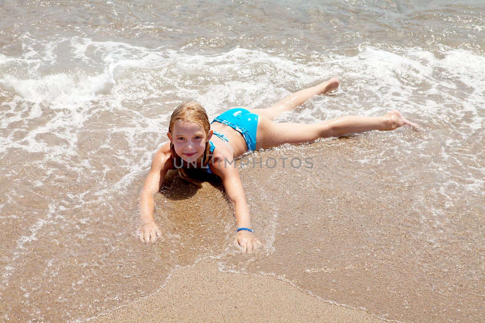 child on the beach in waves and water