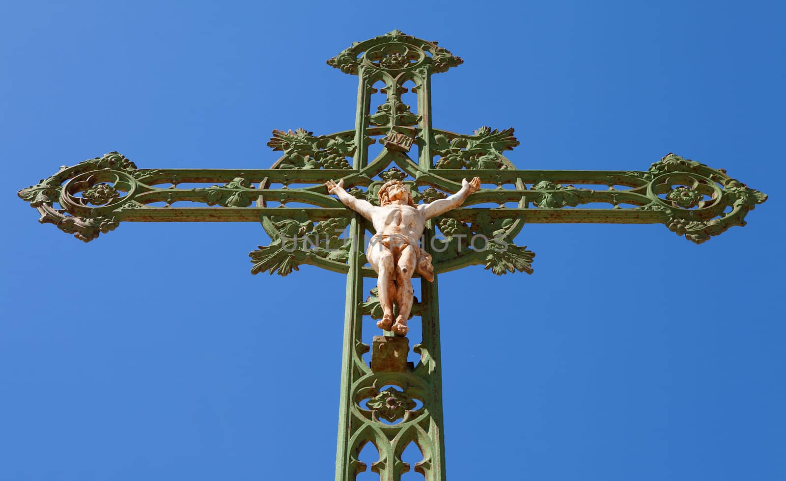 Statue of jesus on cross against blue sky