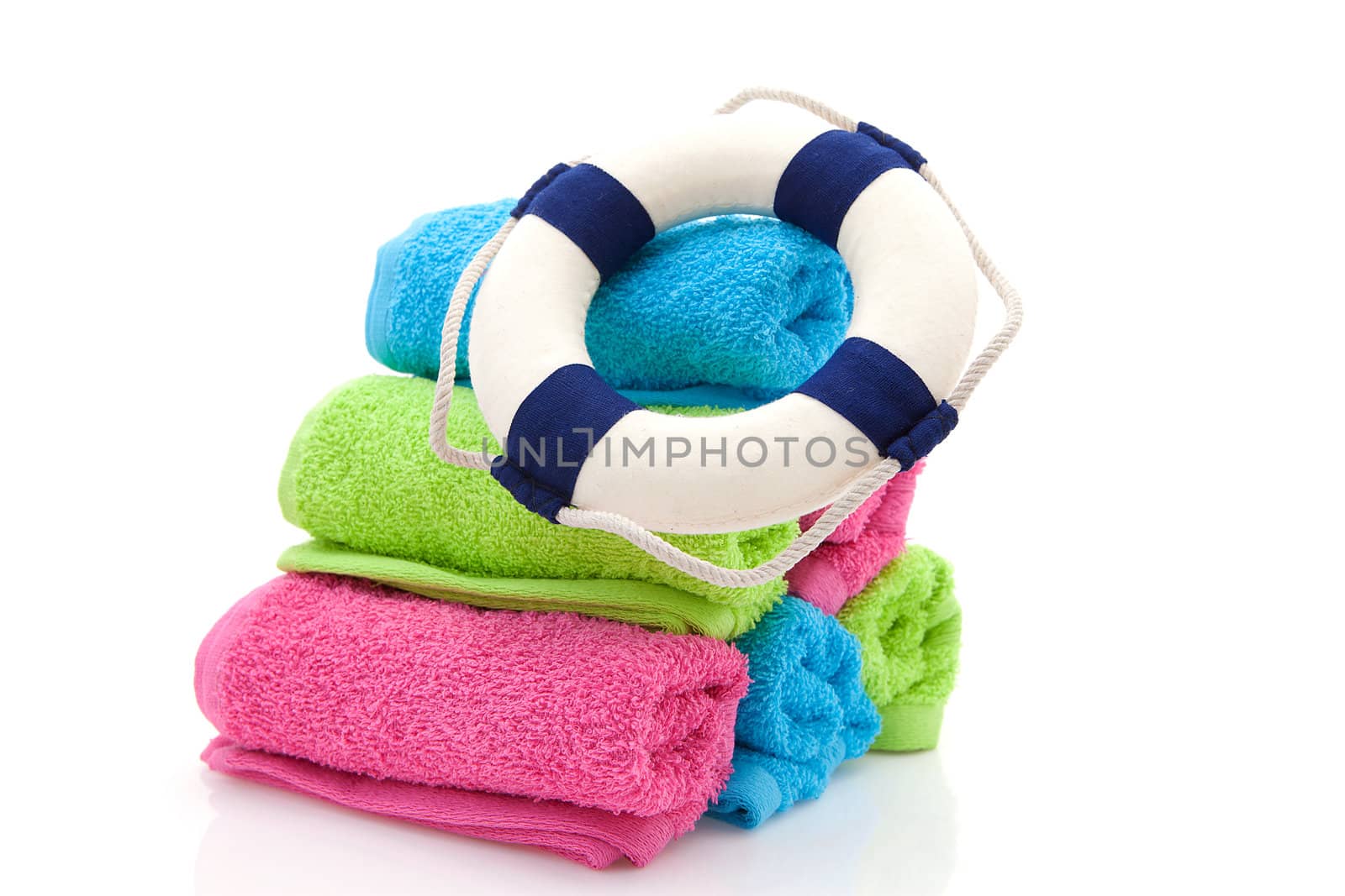 summer gear; colorful towels and life buoy over white background