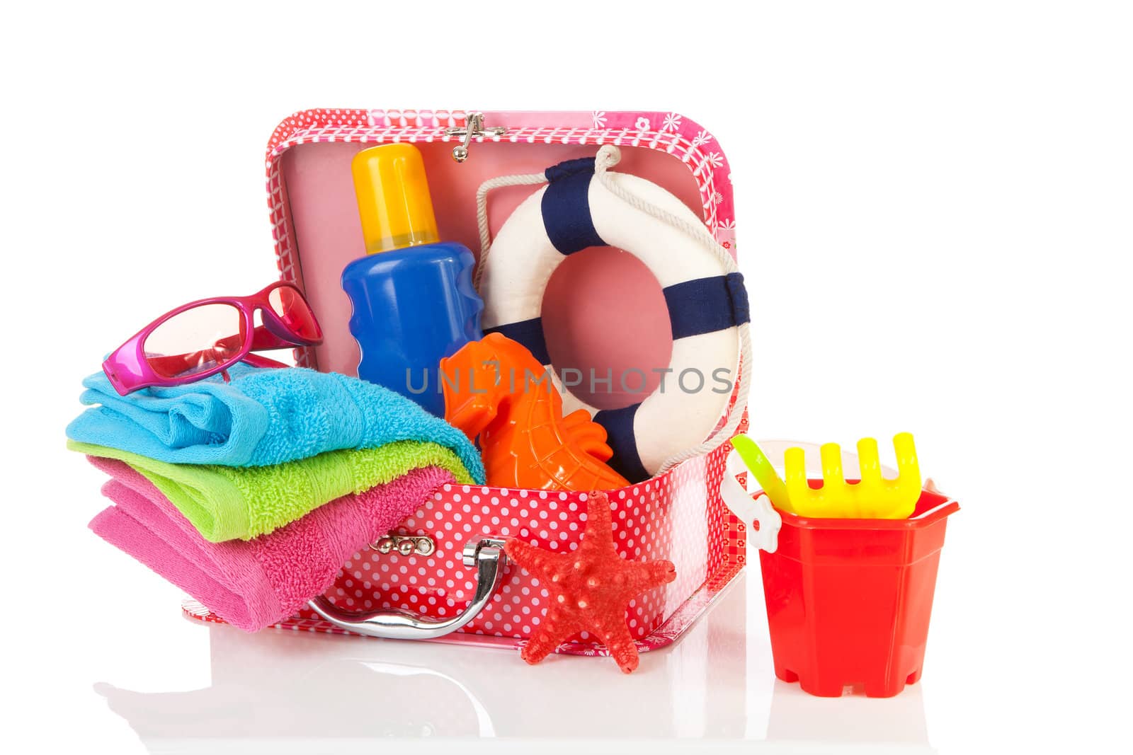 Going to the beach; accessories and suitcase over white background