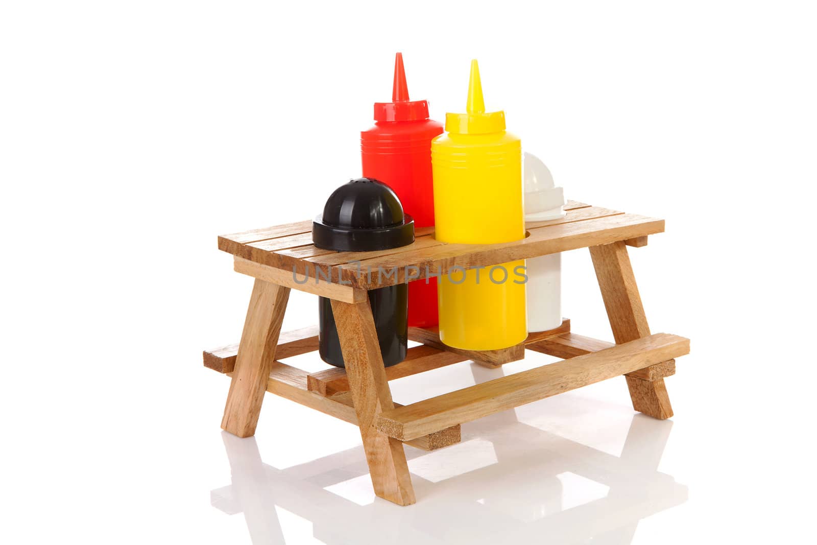 picnic table with salt, pepper and sauce bottles over white background